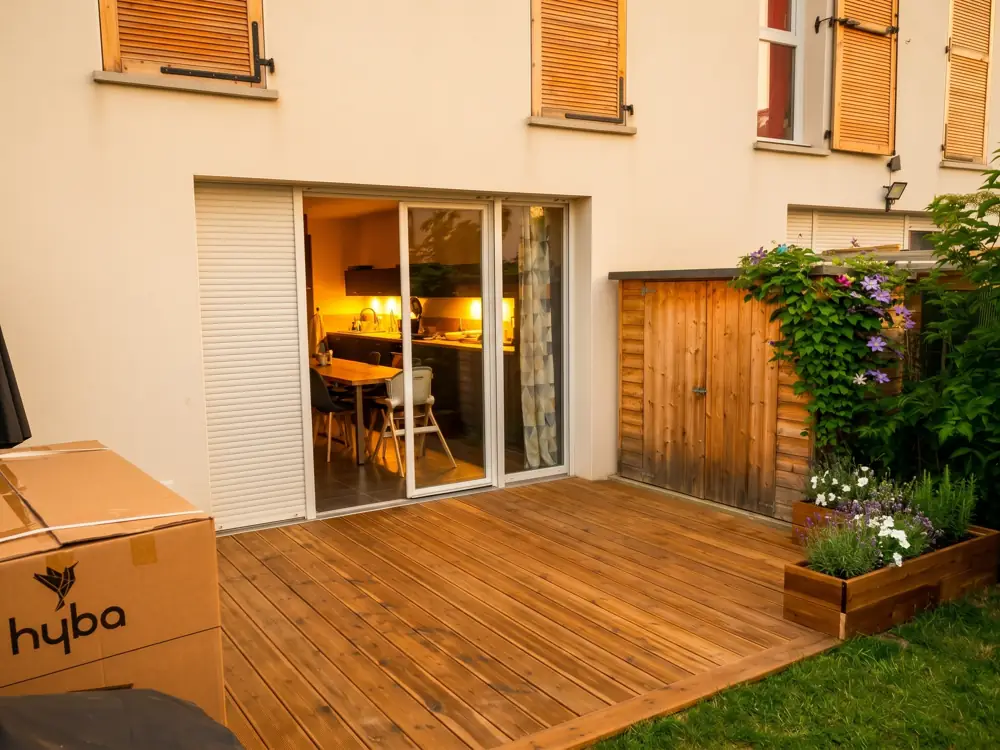 Terrasse en bois avec jardinière et coffre de rangement le long de la maison